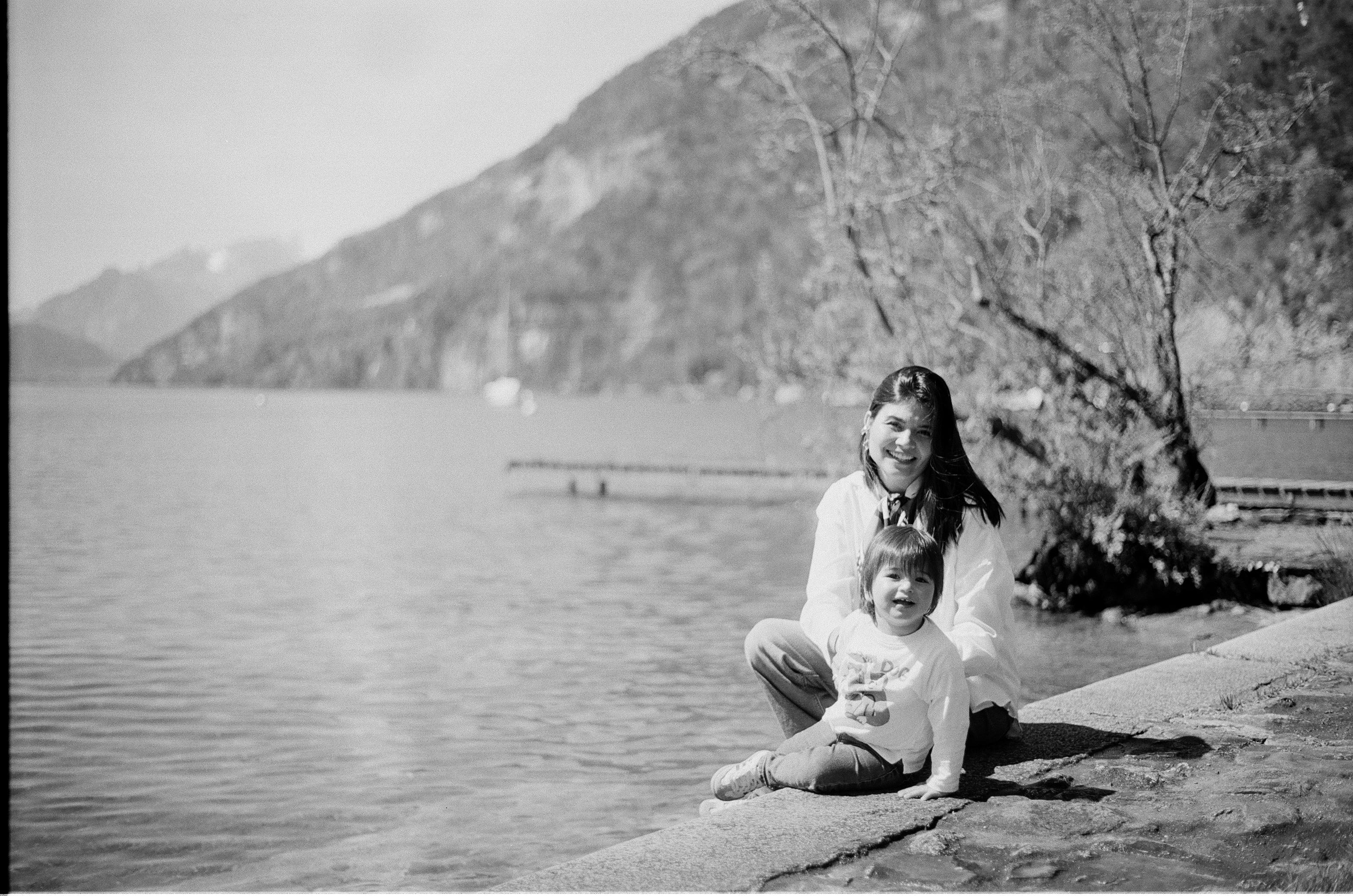 Andrea con su hija sentadas junto al lago